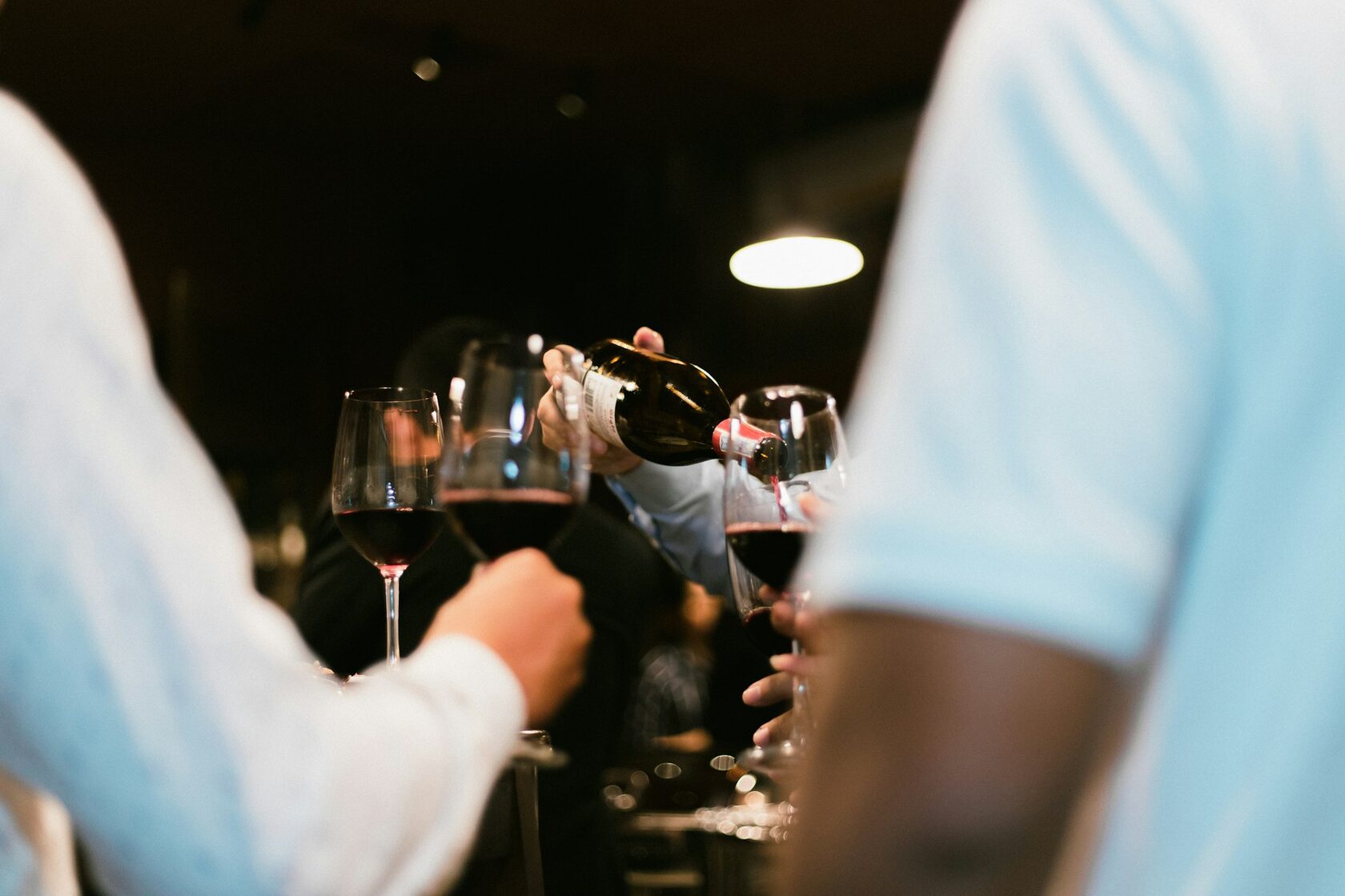 Red wine being poured into a tasting glass